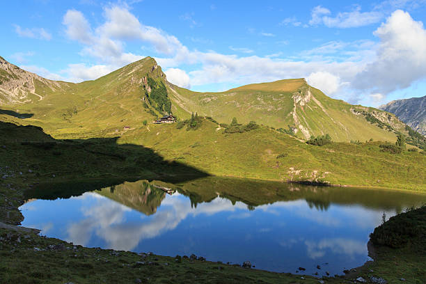 горы и горнолыжный хижина с отражением на озеро - rote spitze стоковые фото и изображения