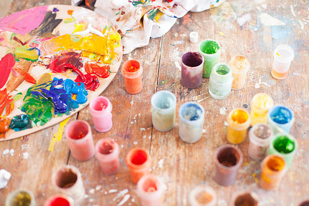 istock Painter's tools on table-oil paints cans, palette and durty pattern 520327204