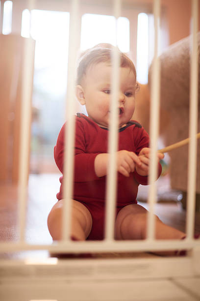 istock Baby boy waits behind baby gate 520327538
