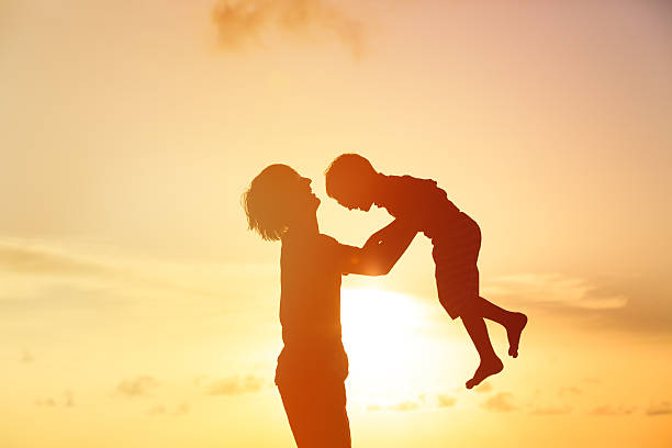 istock father and little son silhouettes play at sunset 520330404