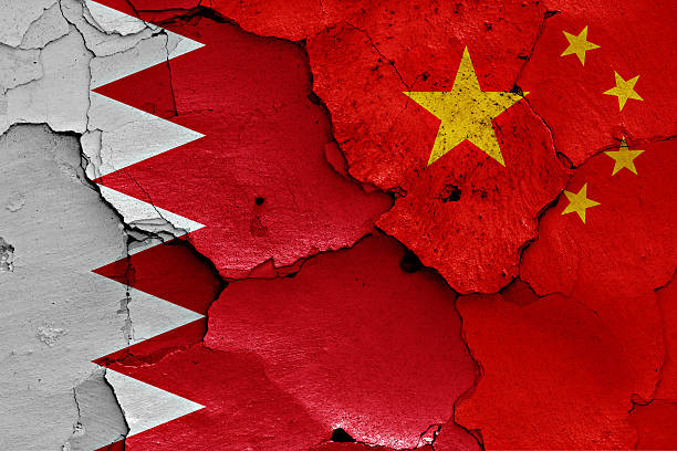 istock flags of Bahrain and China painted on cracked wall 520332108