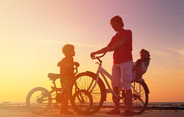 istock father with two kids on bikes at sunset 520332448