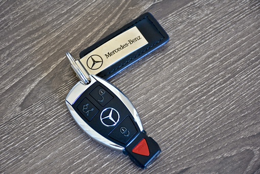 Odenton, USA - April 10, 2016: A Mercedes-Benz key fob laying on a wood surface. Mercedes-Benz is a luxury car manufacturer and dealer.
