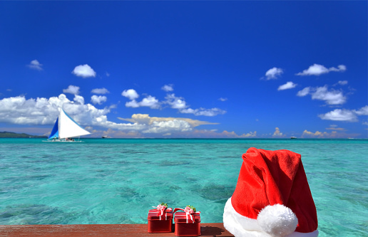 Santa hat and gift box near the beautiful tropical sea
