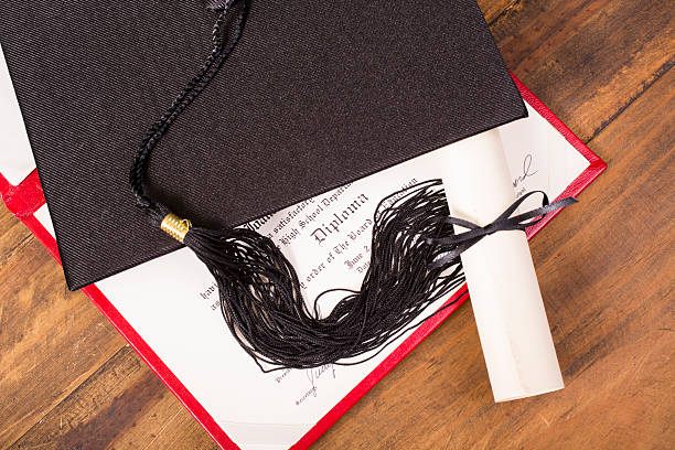 istock Graduation!  Cap, motarboard and tassel with dilplomas on table. Education. 520334714