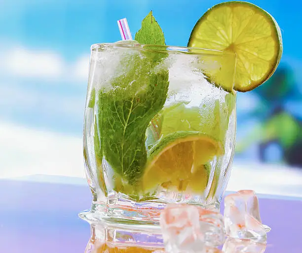 Photo of Mojito cocktail drink. Glasses with lime , ice, and leaf of