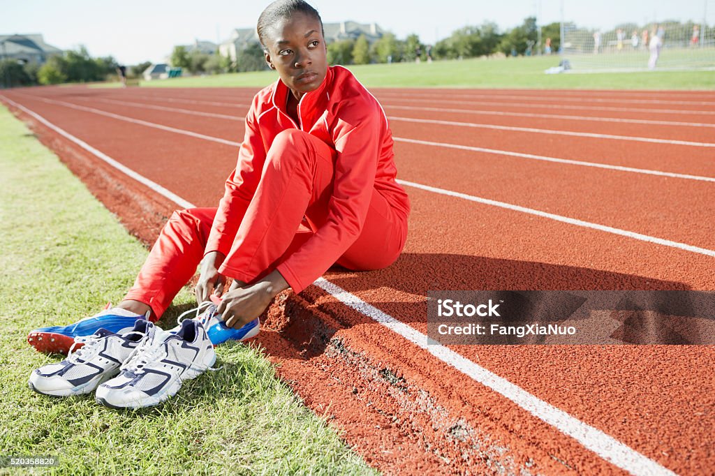 Track and field athlete putting on shoes Women Stock Photo