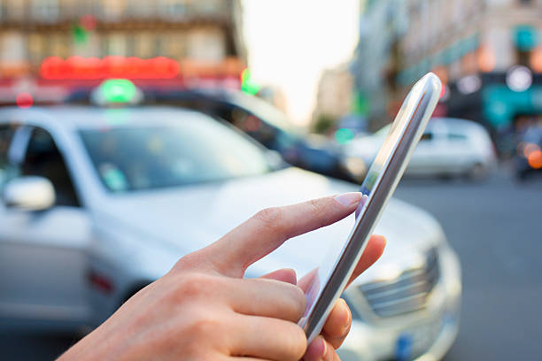 mulher pedidos um táxi a partir do seu telemóvel - fazendo sinal com a mão imagens e fotografias de stock