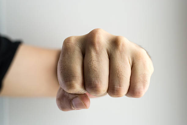 Violent young man giving sleep, danger, fighting sport, boxing. Red light and blurred background. Training, sleep in the fight, athlete practicing sport.