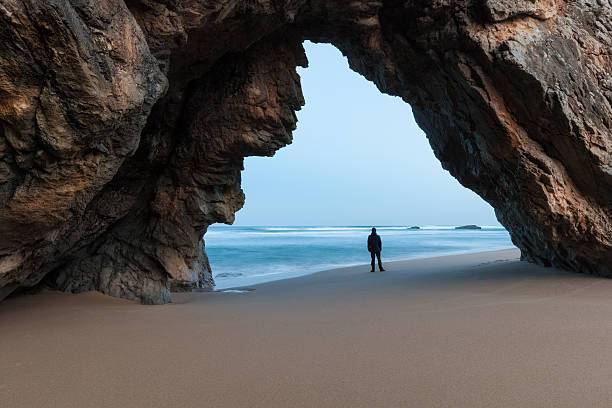 istock Lonely man under the rocky arch 520364208
