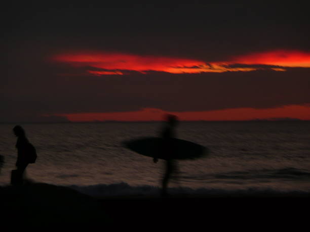 istock backlit off to surf under a dark and red sky 520367252