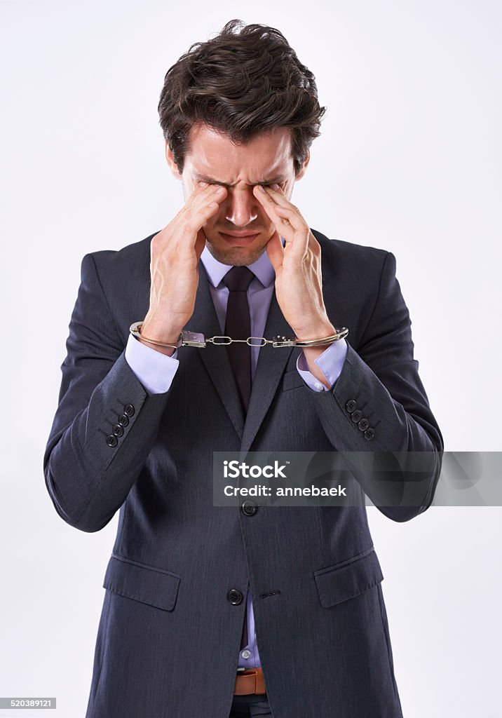 Shackled by stress Studio shot of a handsome young businessman in handcuffs Adult Stock Photo