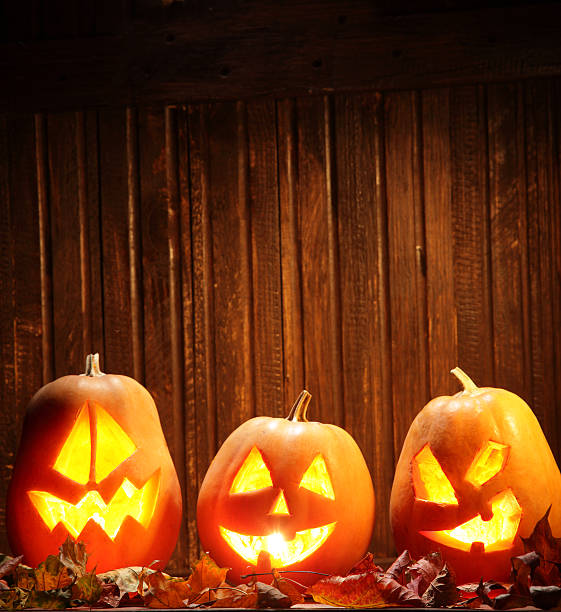 istock Jack o lanterns  Halloween pumpkin face on wooden background 520393833