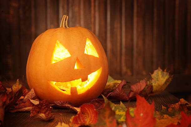 istock Jack o lanterns  Halloween pumpkin face on wooden background 520393959