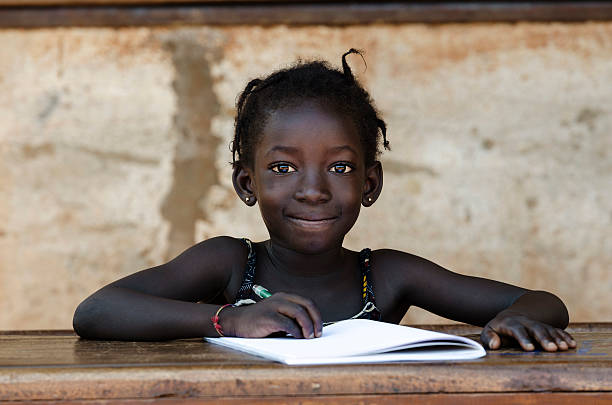 教育: 豪華なポートレートの伝統的なアフリカの学校女の子書き込みレター - african descent africa african culture classroom ストックフォトと画像