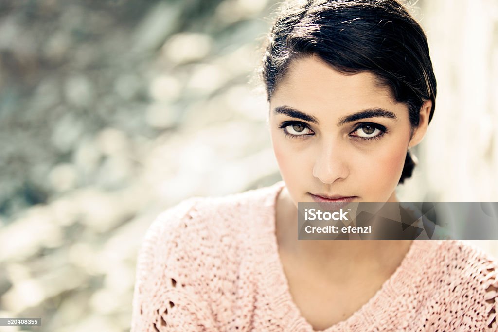 Portrait Of Attractive Woman With Brown Eyes Portrait of an attractive woman in pink sweater with long hair and brown eyes looking at the camera. Photo taken in a quarry on a hot summer day. 20-29 Years Stock Photo