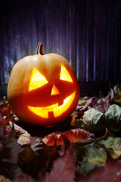 istock Jack o lanterns  Halloween pumpkin face on wooden background 520408775