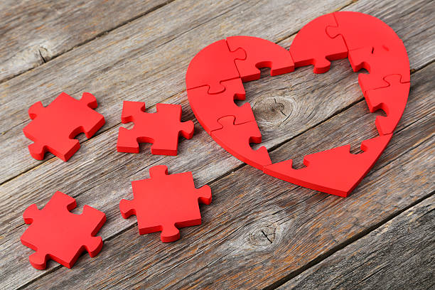 istock Red puzzle heart on grey wooden background 520410532