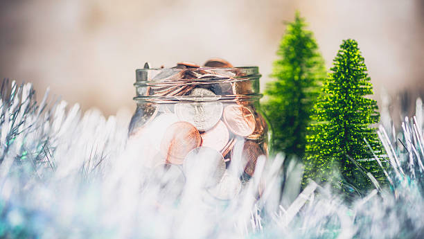istock Glass jar filled with coins in Christmas setting. 520410609