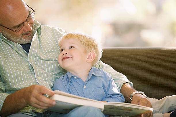 дедушка читает с внуком - grandparent family reading inside of стоковые фото и изображения