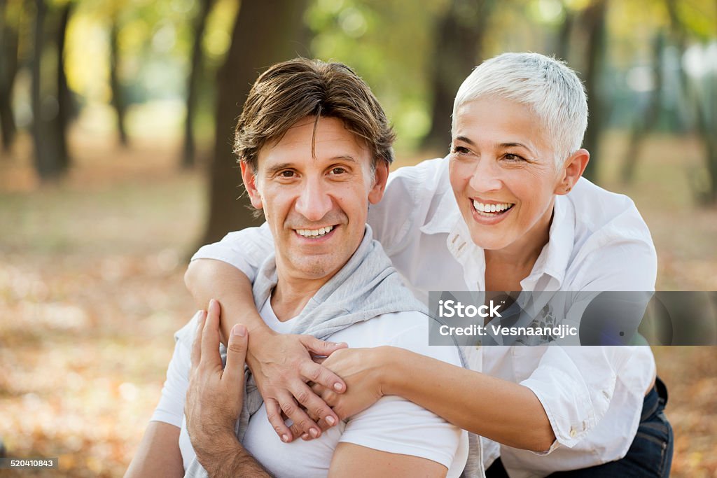 Portrait of loving mature woman embracing man from behind 40-44 Years Stock Photo