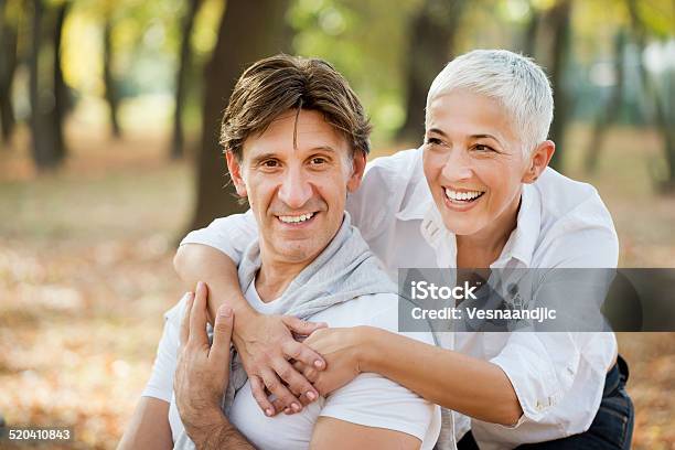 Portrait Of Loving Mature Woman Embracing Man From Behind Stock Photo - Download Image Now
