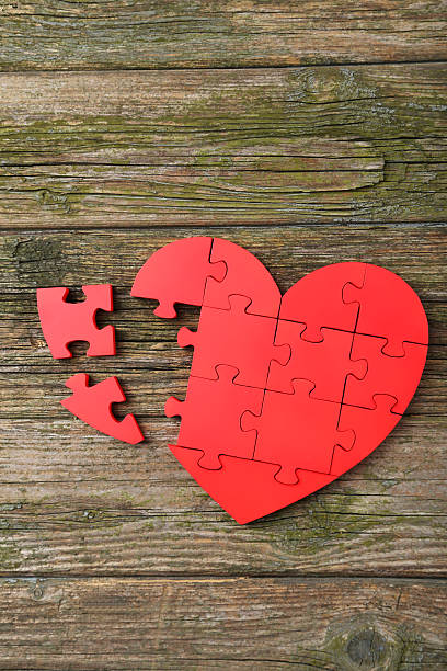istock Red puzzle heart on wooden background 520411226