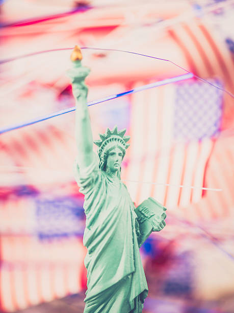 istock Statue of Liberty in front of American flags 520411379