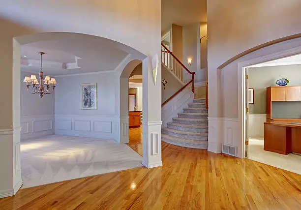 Luxury house interior with new hardwood floor, archways and staircase