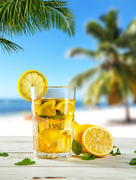istock Glass of summer ice tea drink on beach 520411870
