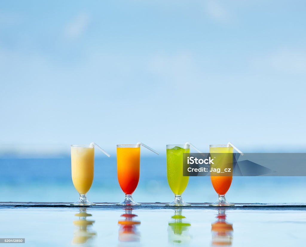 Cocktails drinks placed next to swimming pool Fresh summer cocktails drinks placed next to swimming pool with ocean on background. Alcohol - Drink Stock Photo