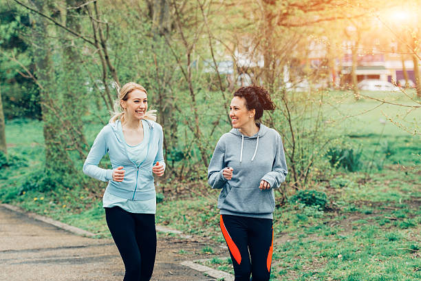 istock Two young female running together in city environment 520413614