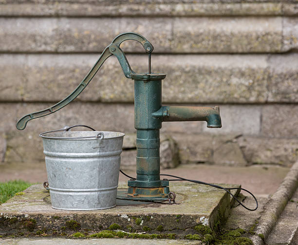 Old well pump with water stream.