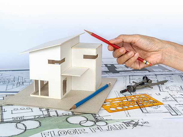 istock Architect working with house model & blueprints/ housing development business 520413874