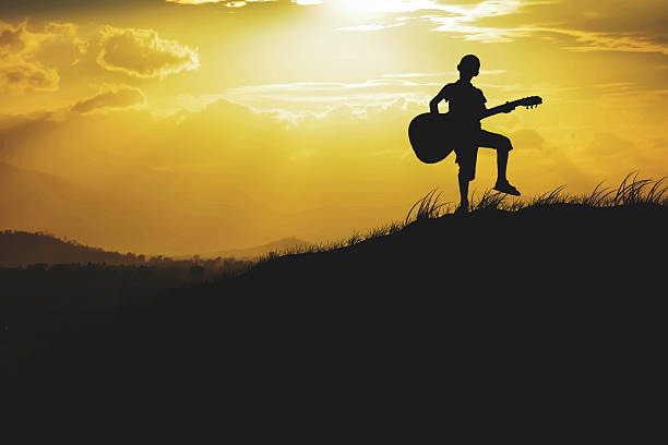istock silhouette of dancing boy holding guitar 520413920
