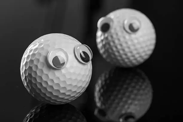 Photo of Two golf balls with plastic eyes