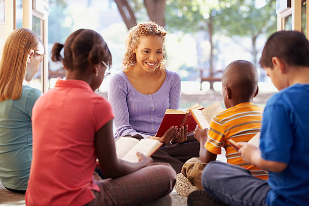 istock Librarian reading to a group of children 520415212
