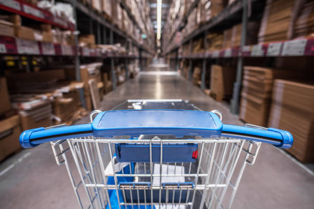 istock Shopping trolley cart before Rows of shelves 520415280