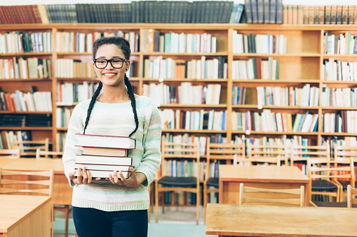 Many books stacked with blurred background of bookstore full of books. Photo with copyspace