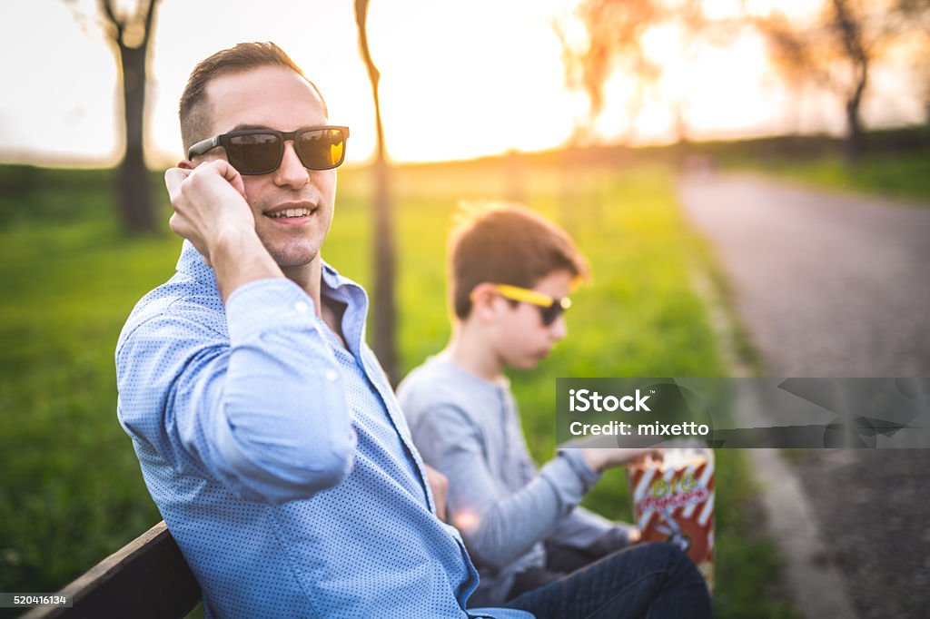 Business father Business father with his son in the park talking on the phone Father Stock Photo