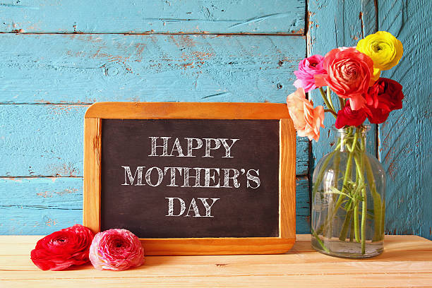 istock flowers next to blackboard. happy mother's day concept 520416390
