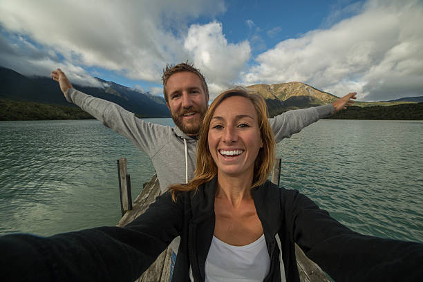 istock Selfie portrait on lake pier, couple having fun 520417042