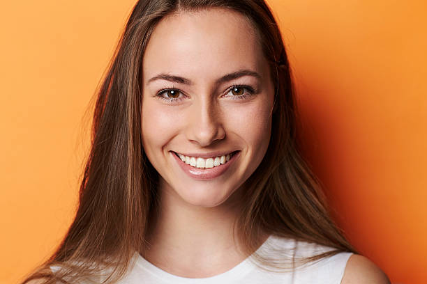 retrato de hermosa morena en orange tipo estudio - brown eyes fotografías e imágenes de stock