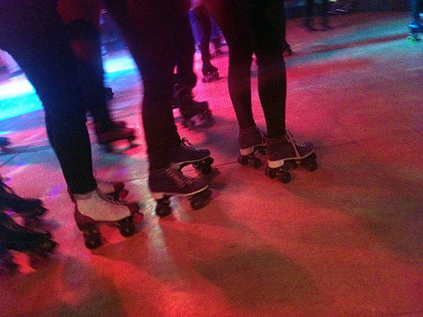 Roller Blade Disco Legs and roller skates on a lit dance floor of a roller disco. Shot with an iPhone. roller rink stock pictures, royalty-free photos & images