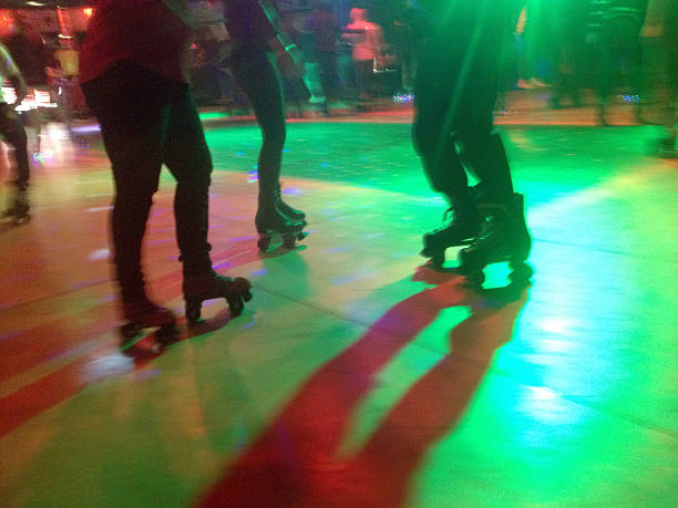 Roller Blade Disco Legs and roller skates on a lit dance floor of a roller disco. Shot with an iPhone. roller rink stock pictures, royalty-free photos & images