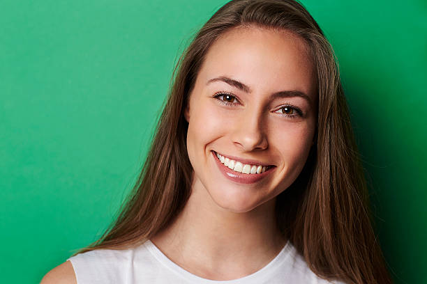istock Young smiling brunette against green background 520419366