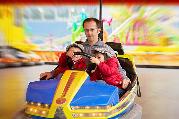 istock Father and his two sons, having ride in bumper car 520419794