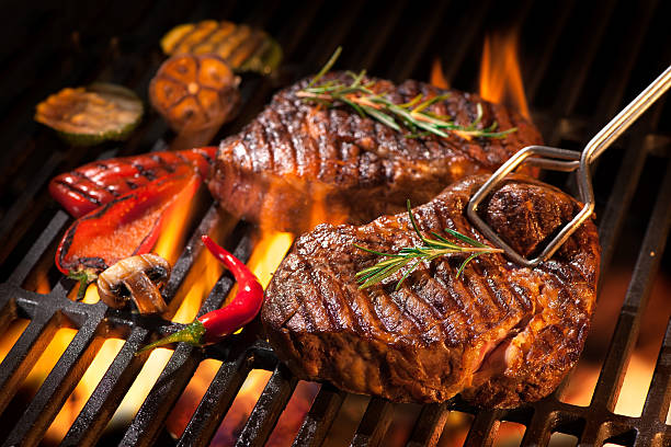 Beef steaks on the grill Beef steaks on the grill with flames steak stock pictures, royalty-free photos & images
