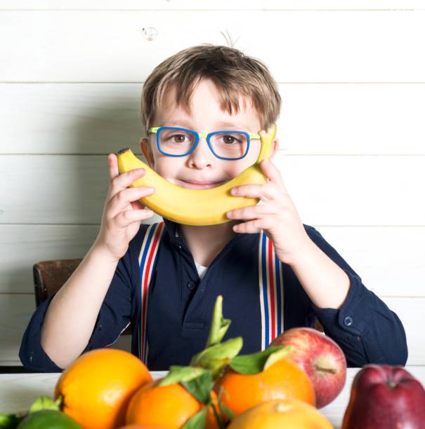 Child And Fruits. Banana like a smile.