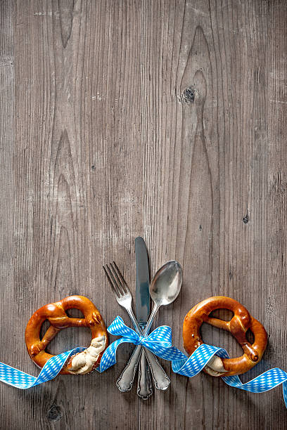 Beer Fest party concept with pretzel and beer glass over wooden background. Top view, flat lay